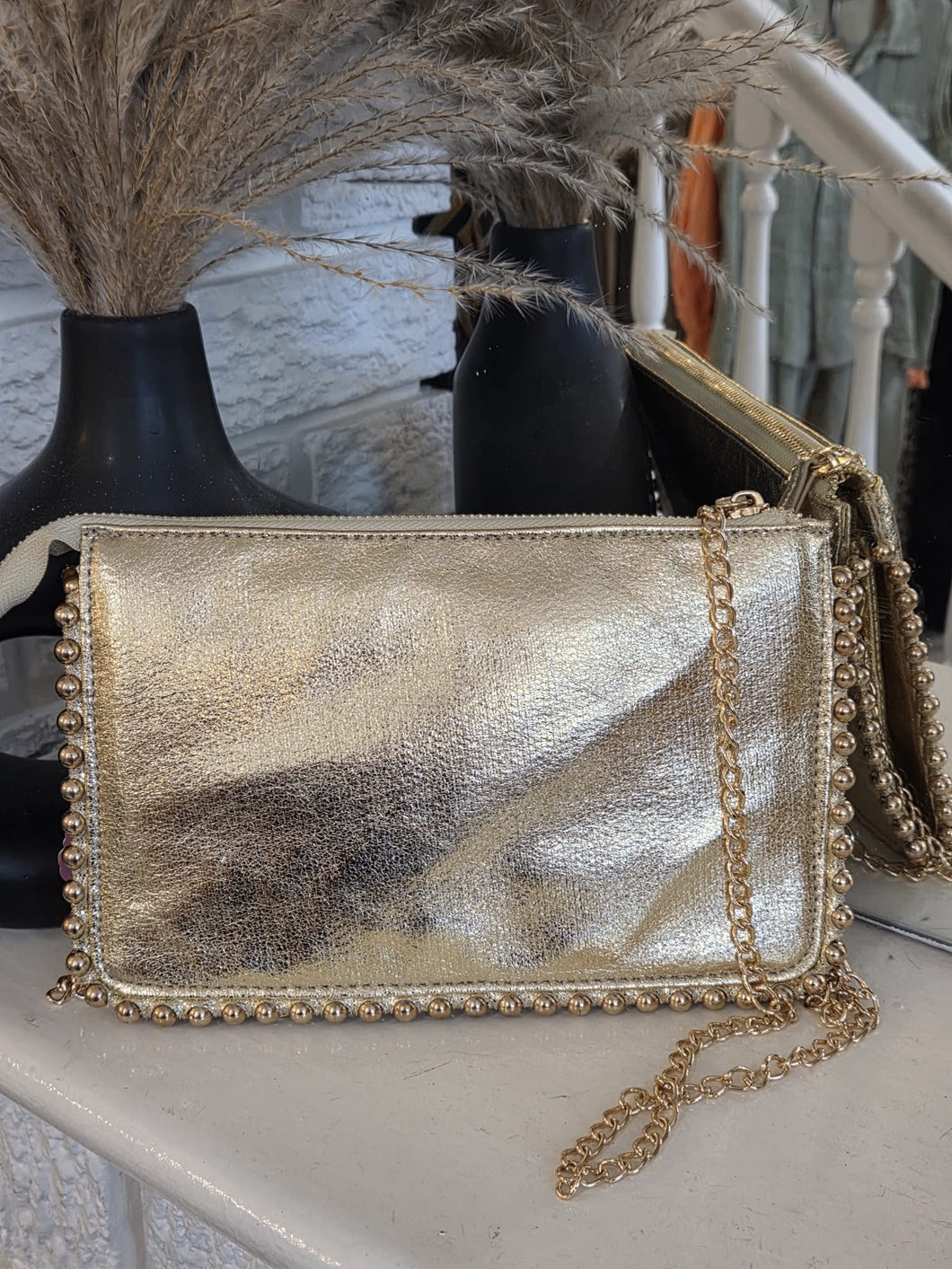 The metallic studded clutch bag with separate shoulder chain